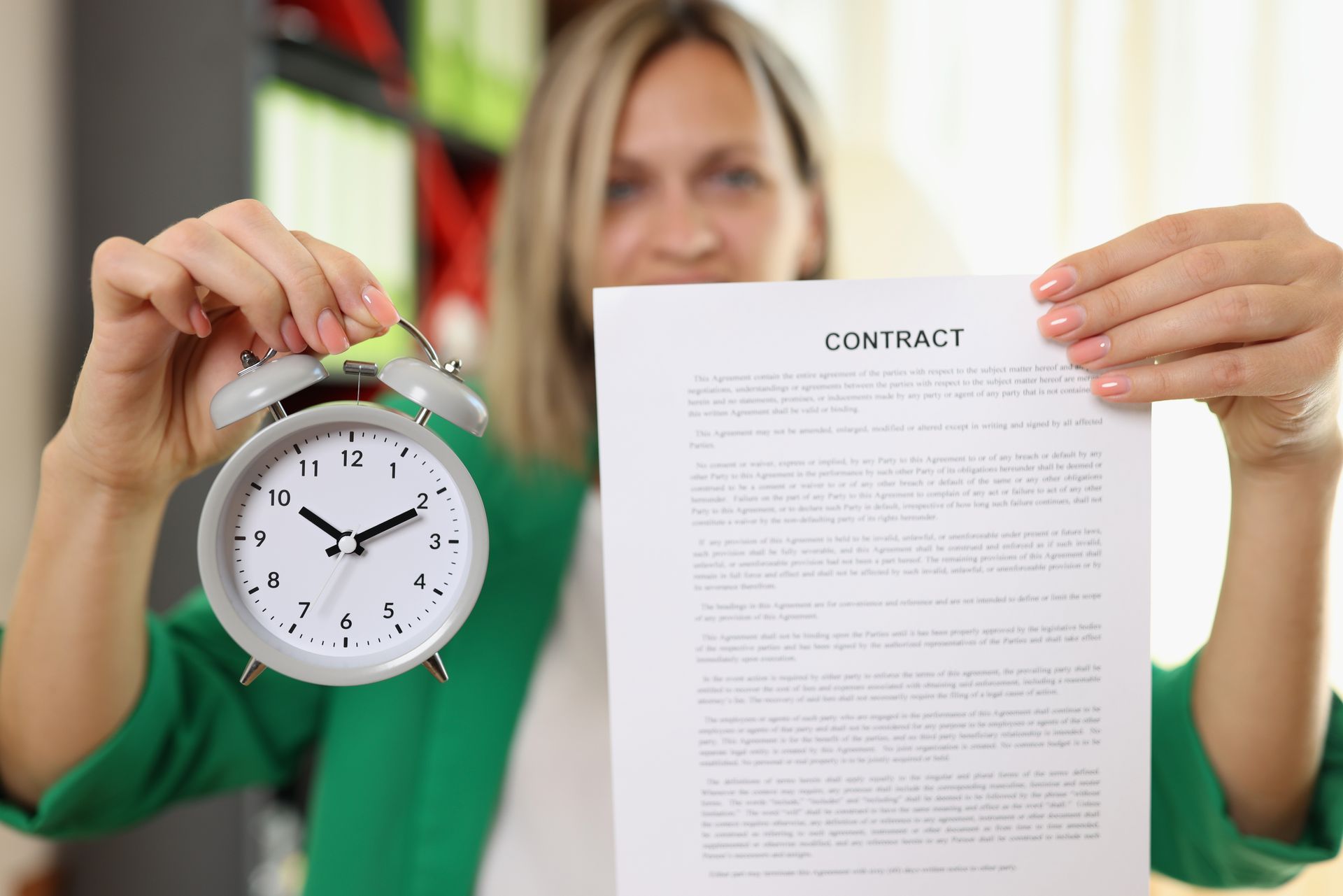 A woman is holding a clock and a contract.