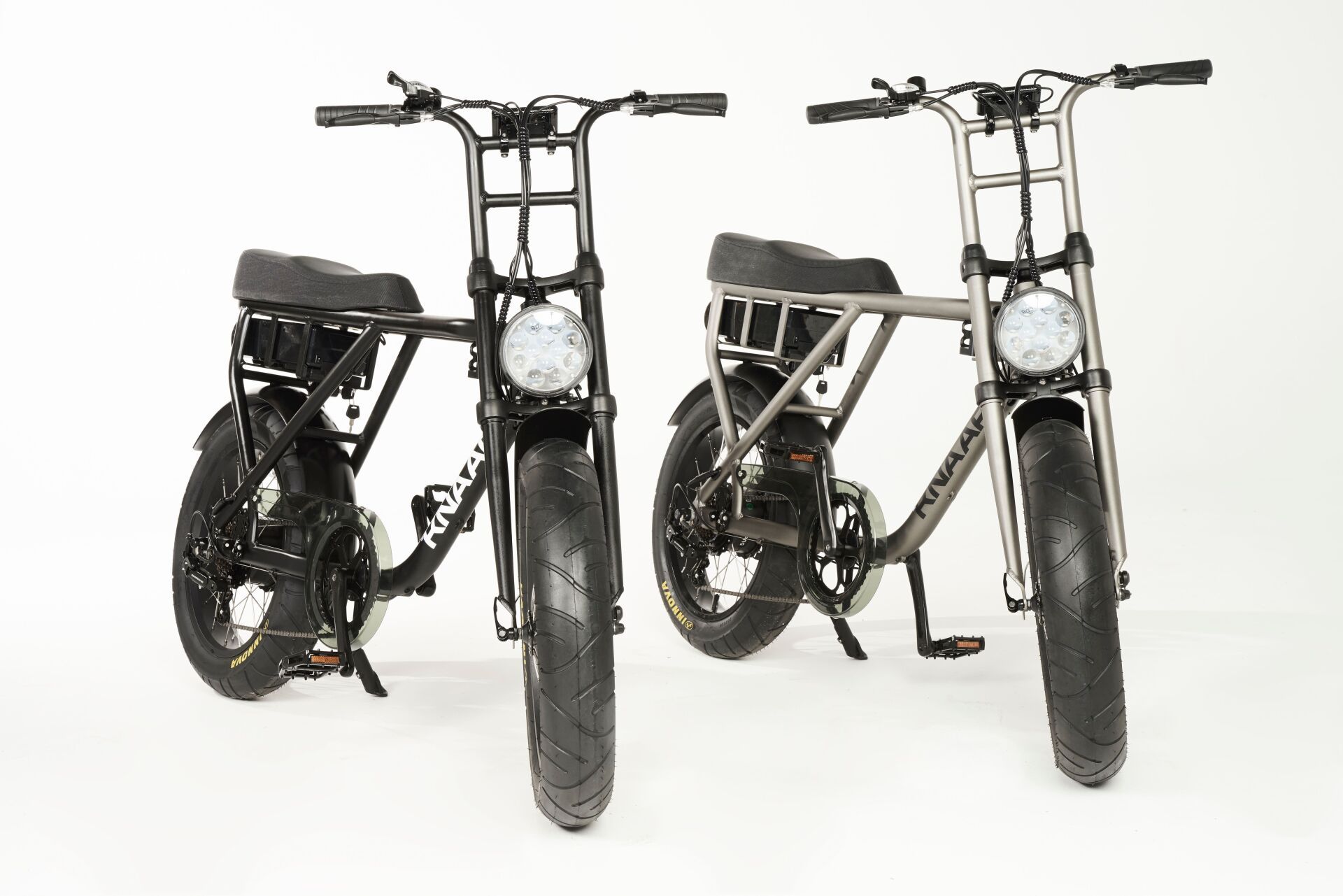 Two compact black folding bikes shown front view on a white background