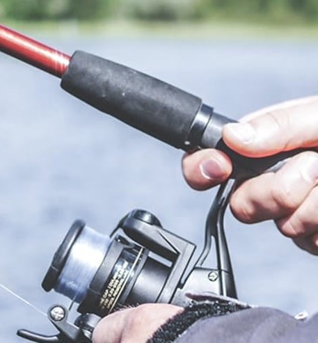 A person is holding a fishing rod and reel in their hands