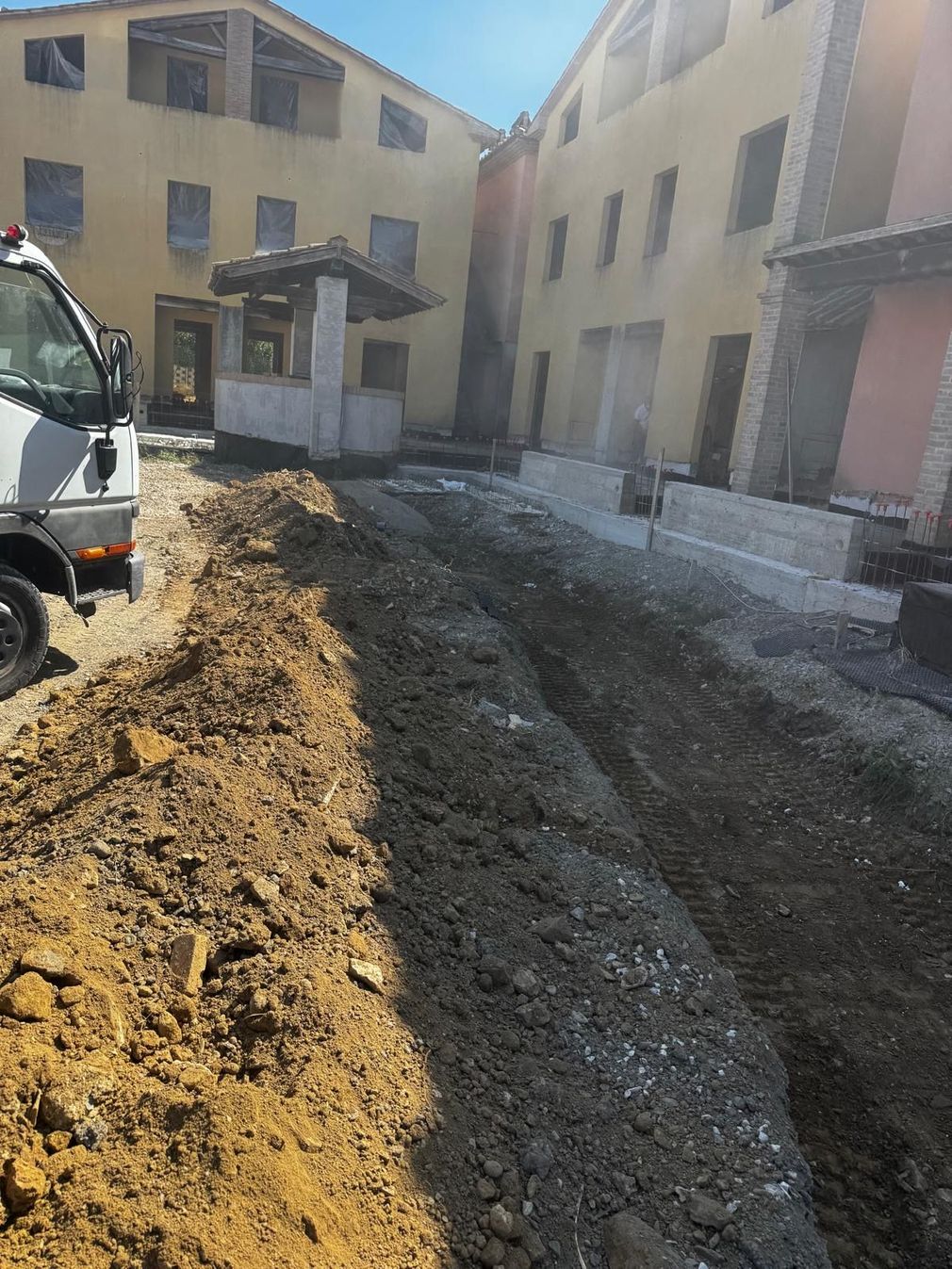 Area di scavo con terreno smosso e attrezzatura edile