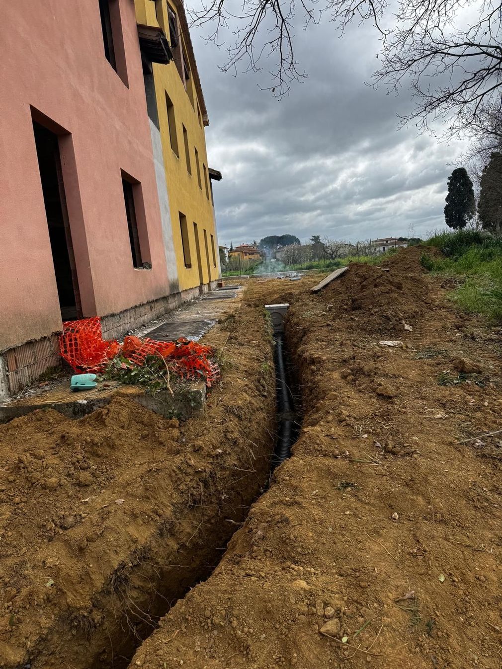 Area di scavo con terreno smosso e attrezzatura edile
