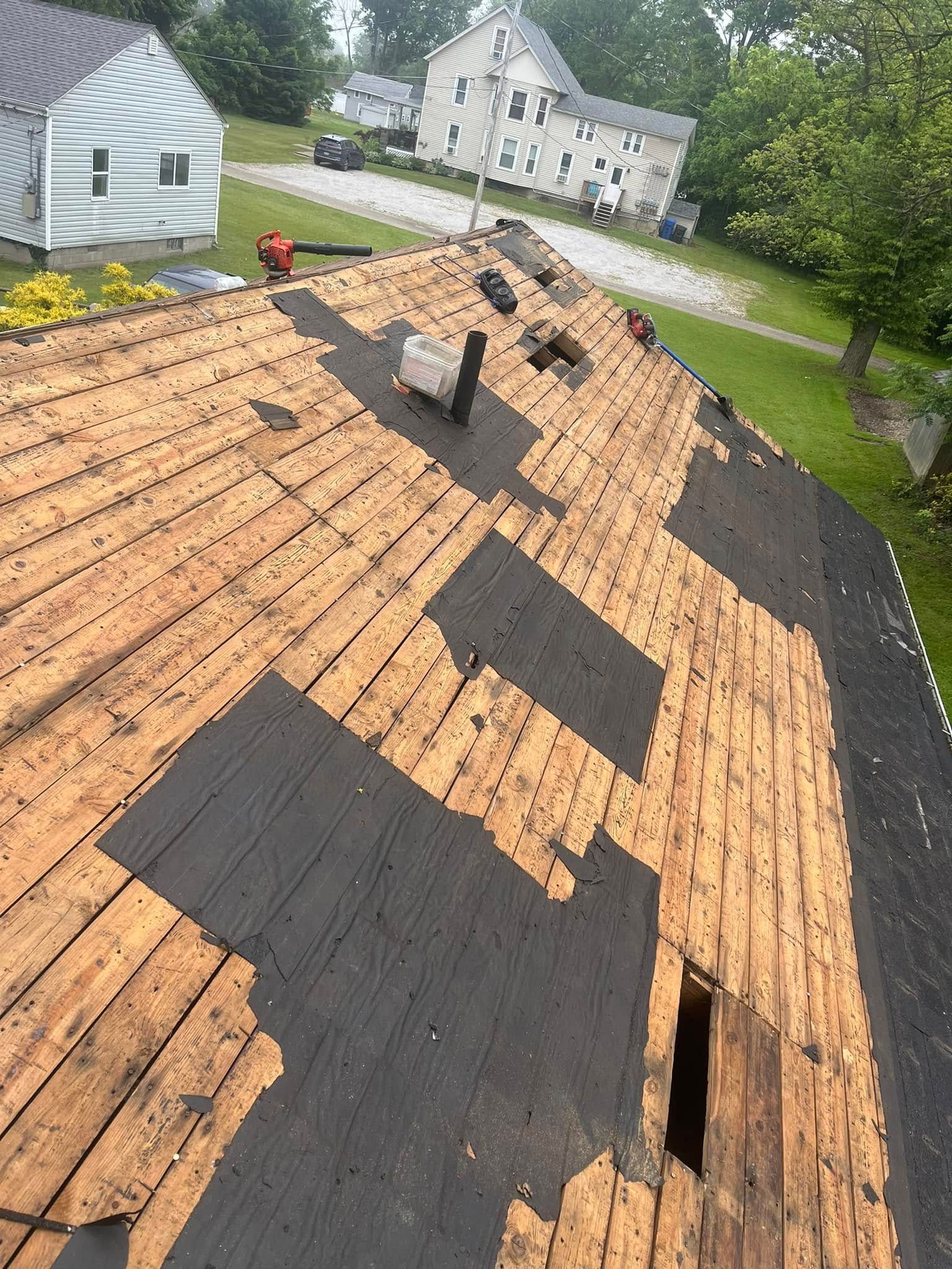 The roof of a house is being repaired and the shingles are being removed.