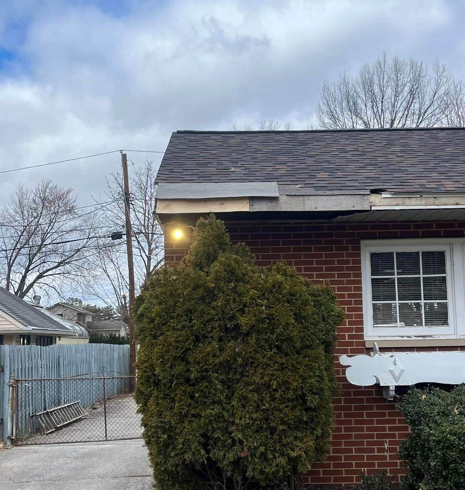A brick house with a roof that is missing shingles