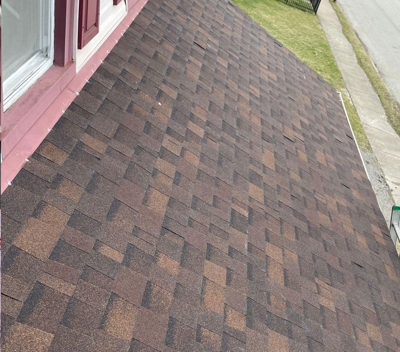 The roof of a house with a brown shingle roof