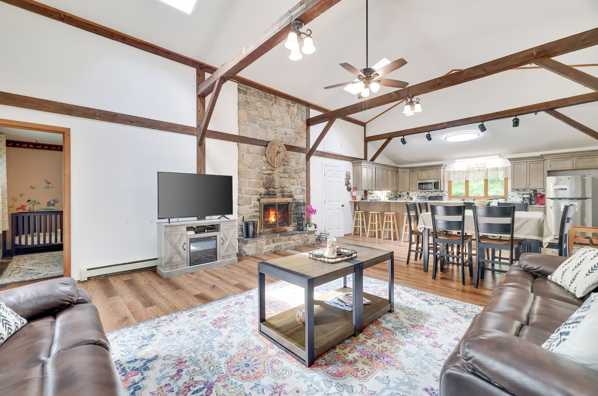 A living room with two couches , a coffee table , a television and a fireplace.
