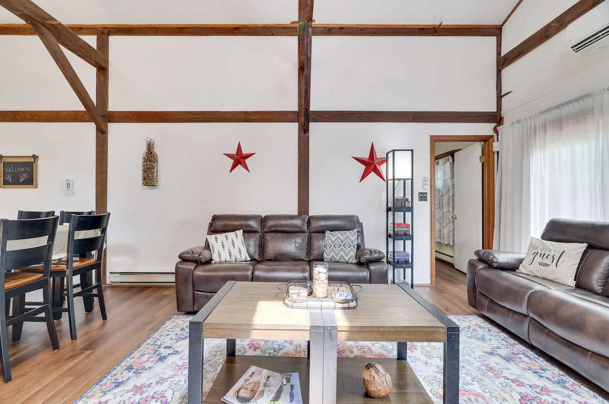 A living room with a couch , coffee table and chairs.