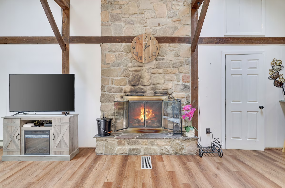 A living room with a fireplace and a flat screen tv.