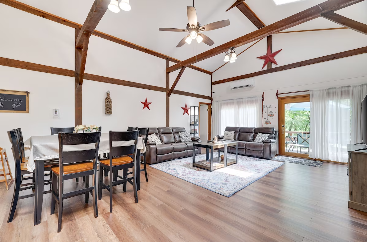 A living room with a dining table and chairs and a ceiling fan.