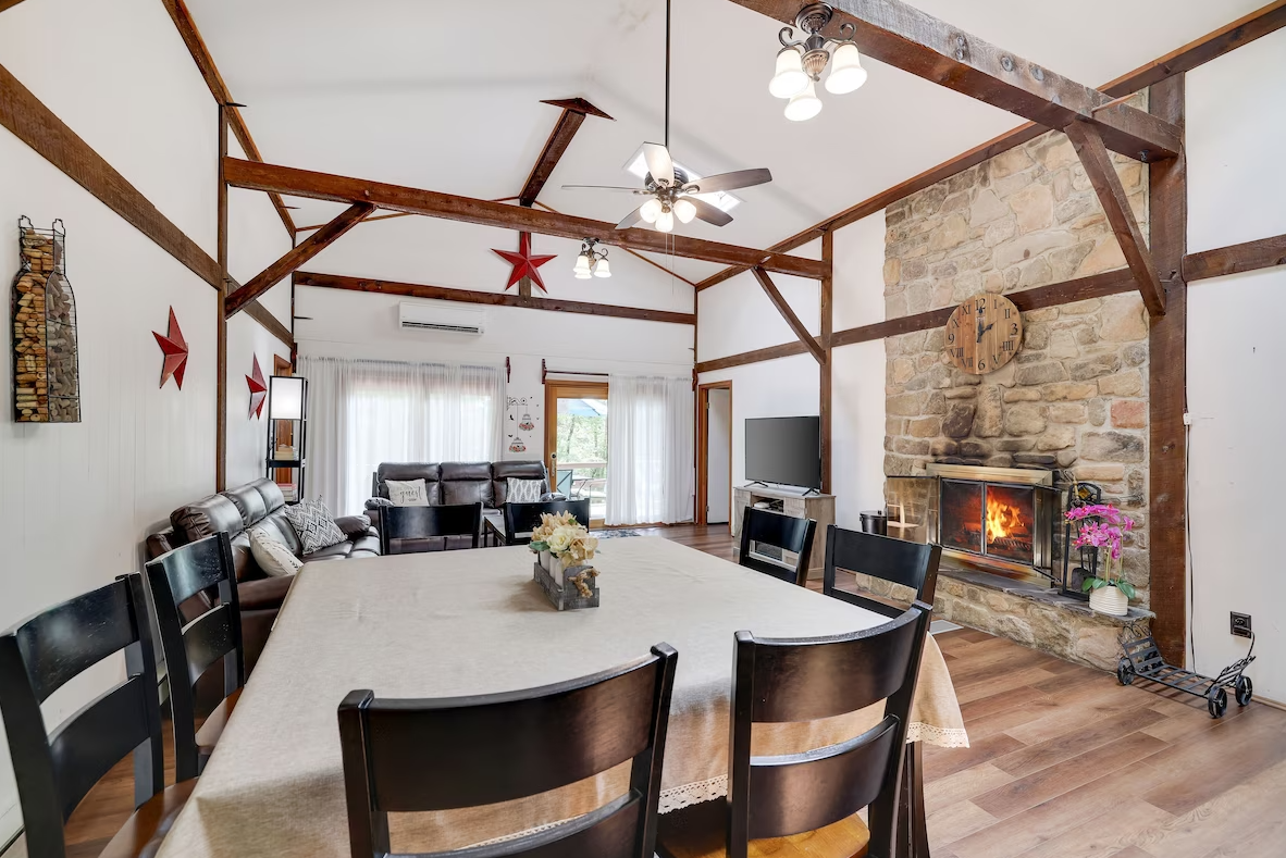 A living room with a table and chairs and a fireplace.