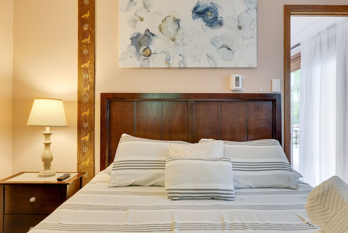 There is a painting on the wall above the bed in the bedroom.