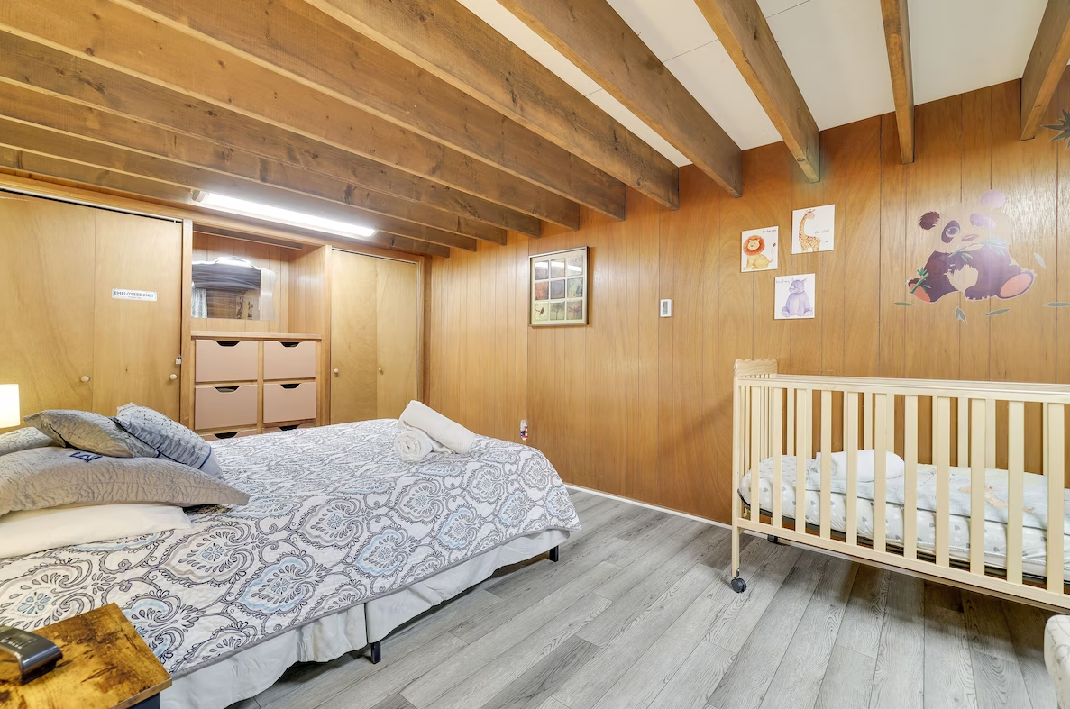 A bedroom with two beds and a crib.