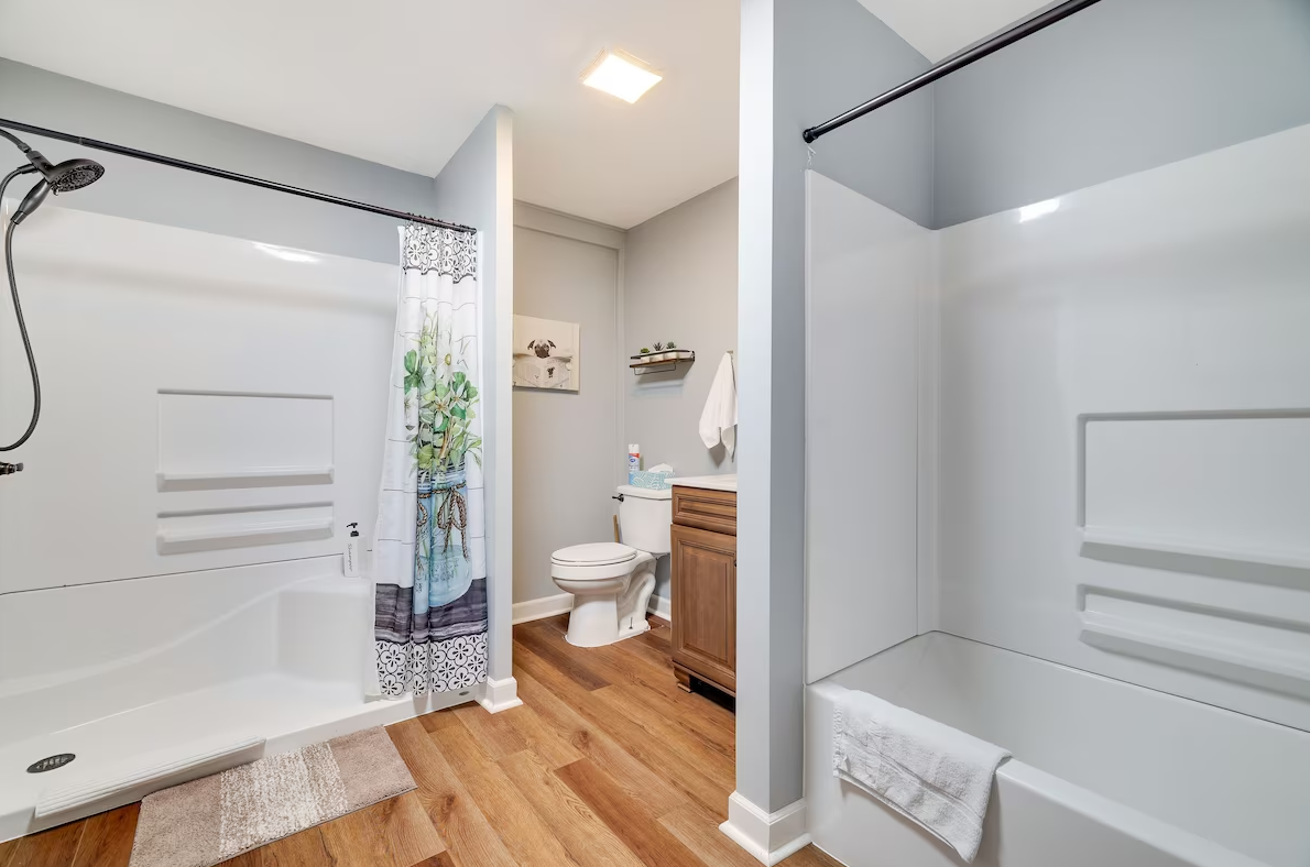 A bathroom with a toilet , sink , shower and bathtub.