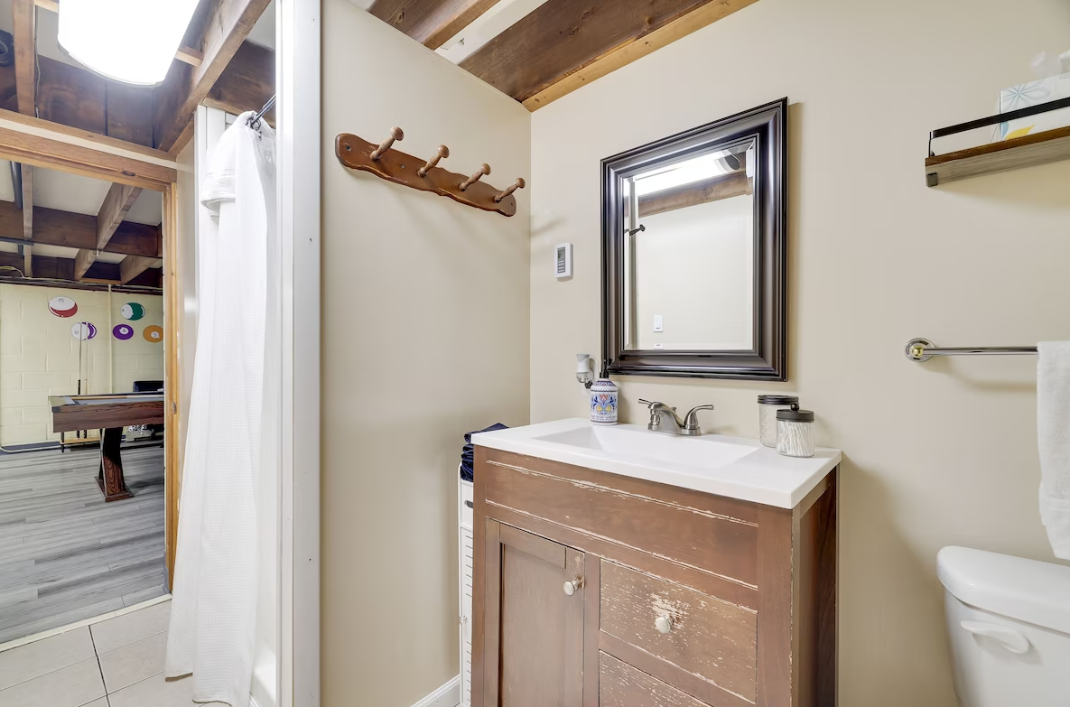 A bathroom with a sink , toilet and mirror.