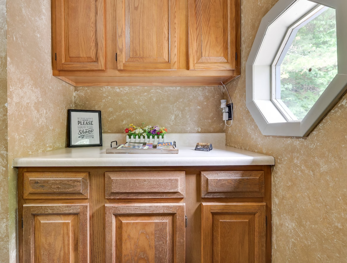A bathroom with wooden cabinets and a window