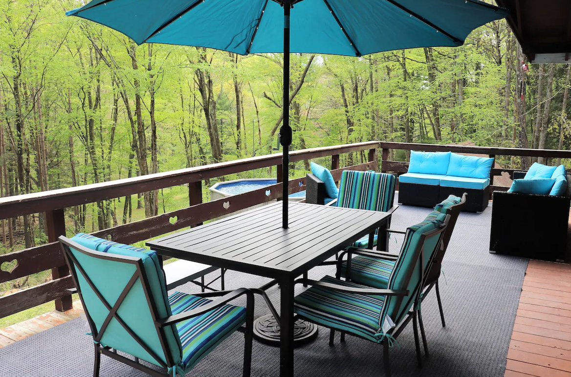 A patio with a table and chairs and a blue umbrella