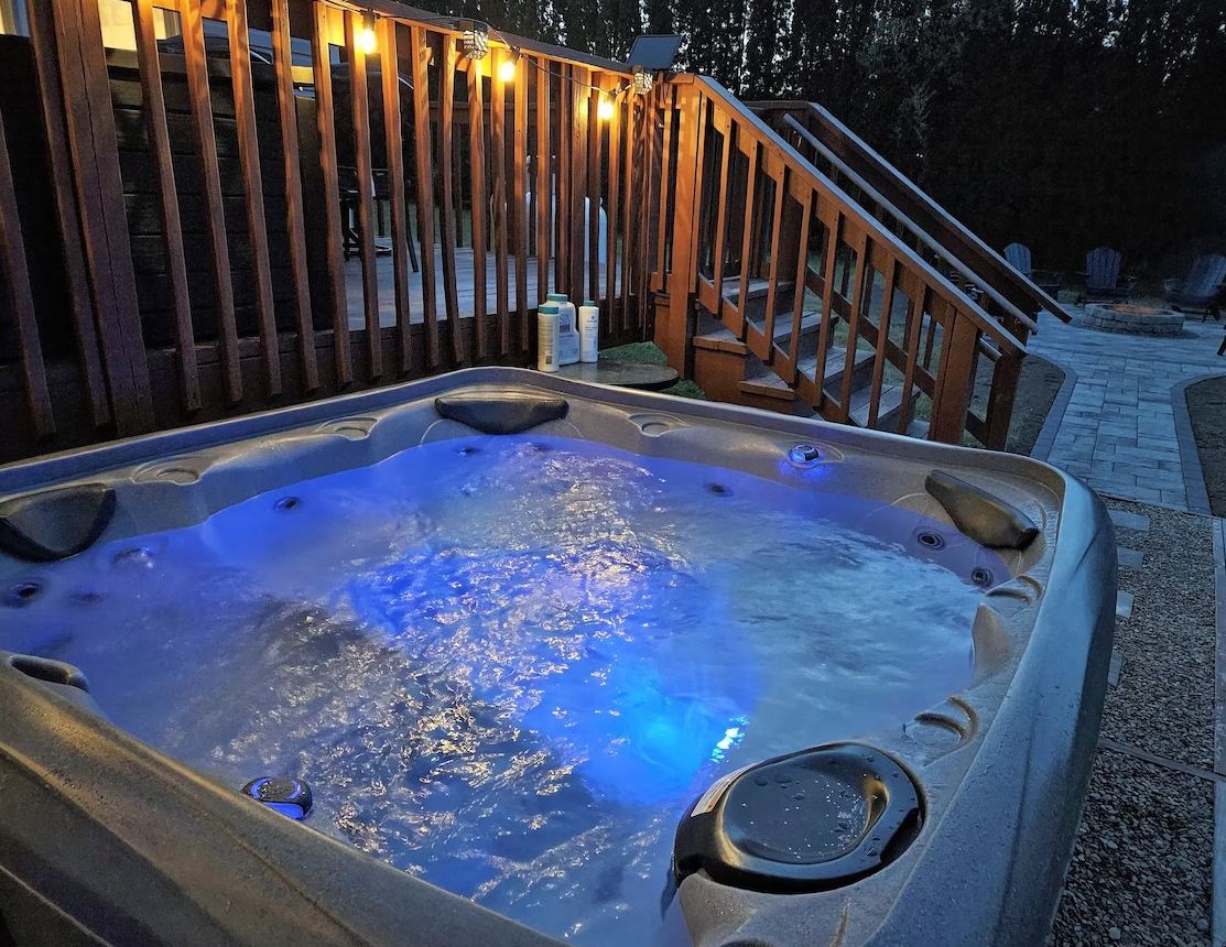 A hot tub on a deck with blue lights on it