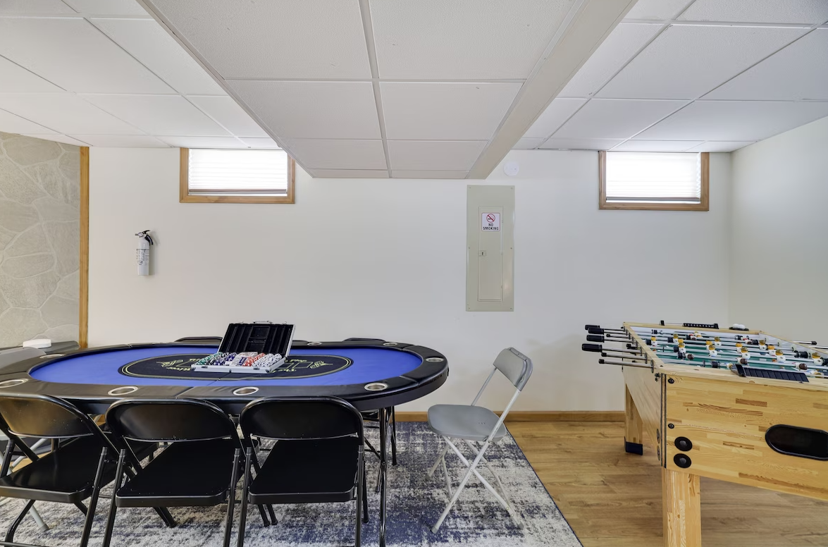 A game room with a table and chairs and a foosball table.