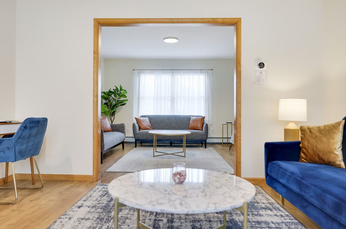 A living room with two couches , a coffee table , and a desk.