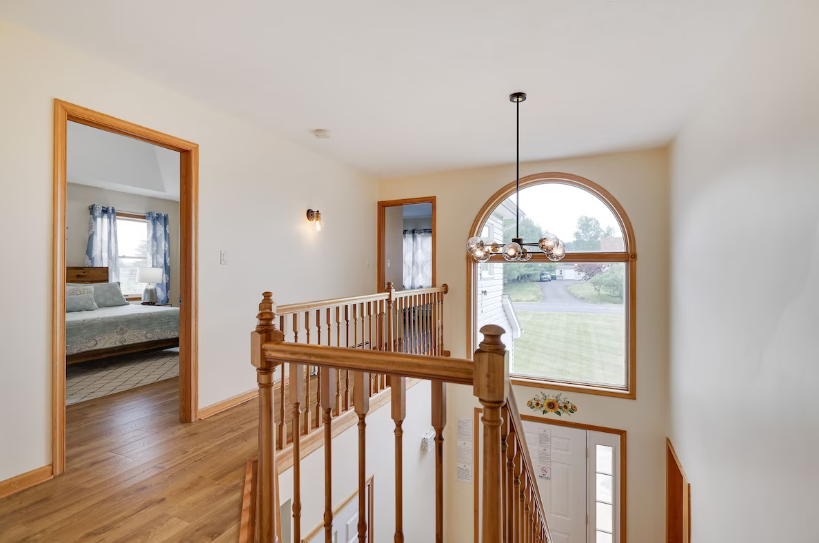 A wooden staircase in a house with a large window