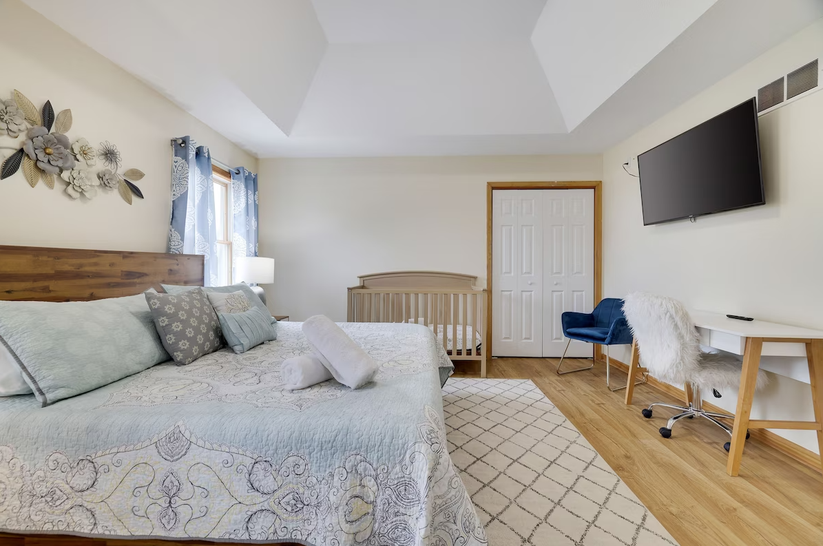 A bedroom with a bed , desk , chair and television.