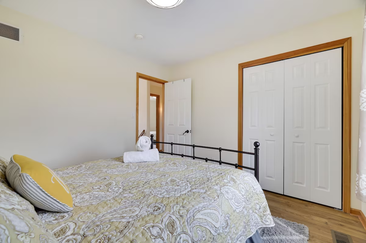 A bedroom with a bed , closet , and window.