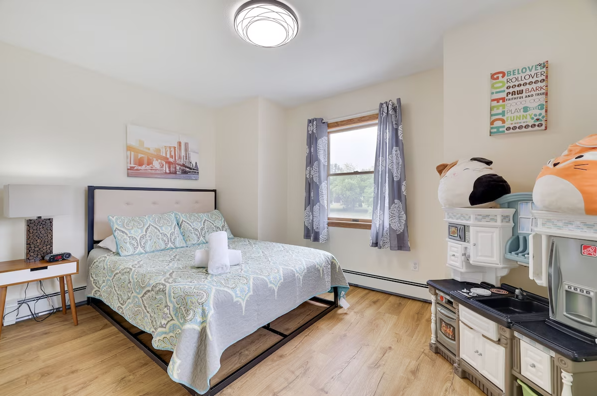 A bedroom with a bed and a toy kitchen.