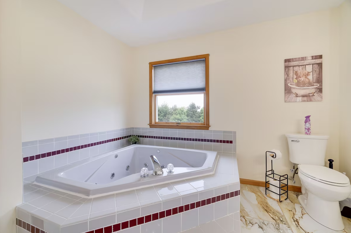 A bathroom with a jacuzzi tub and a toilet