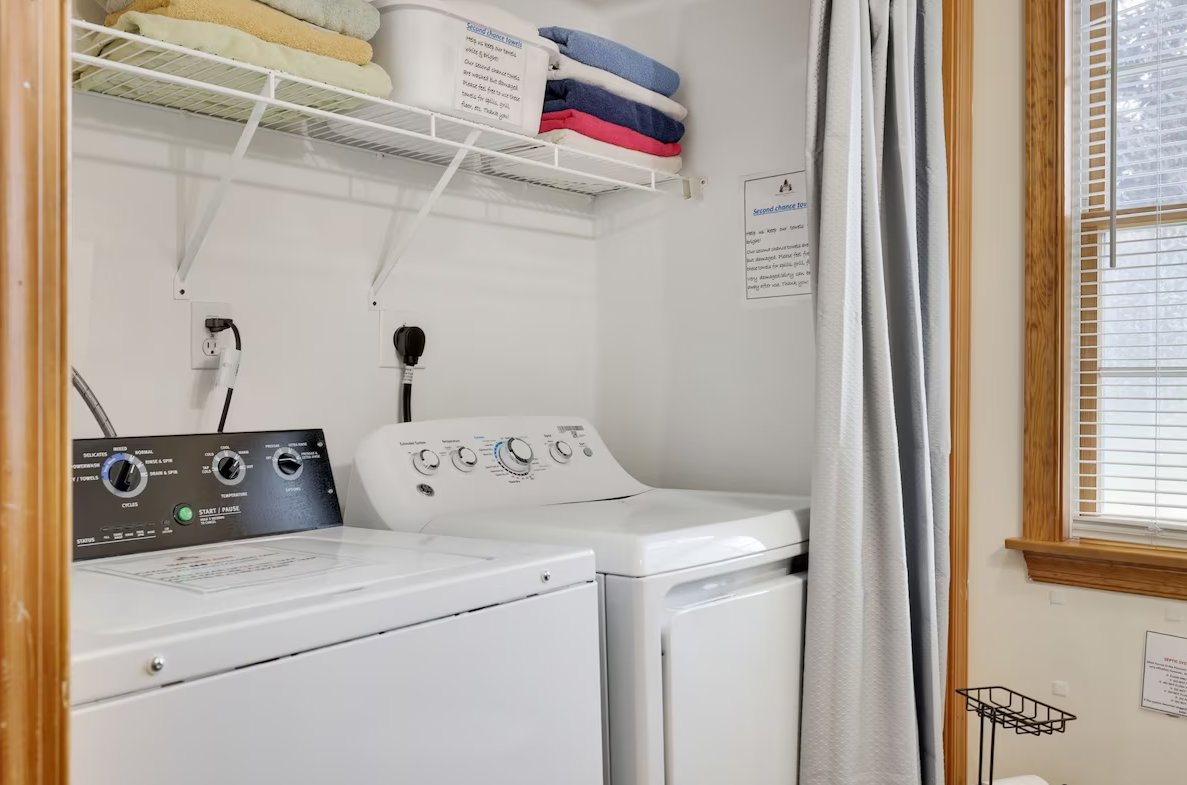 A laundry room with a washer and dryer and a window.