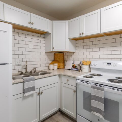 empty kitchen with white cabinets