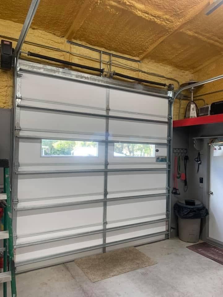 Closed white garage door with small windows inside a workshop-style garage