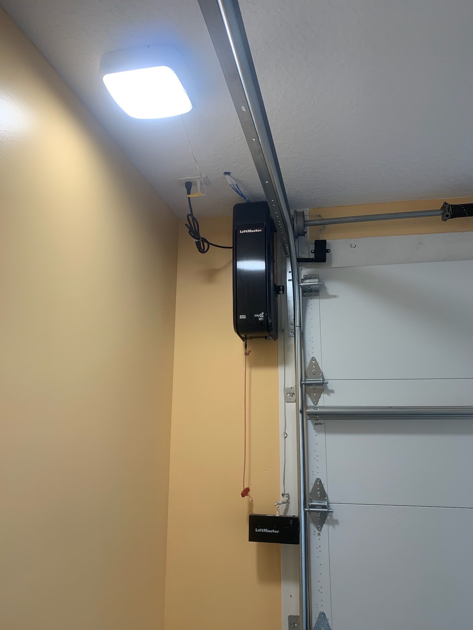 Garage interior with ceiling light, overhead door track, and garage door opener.