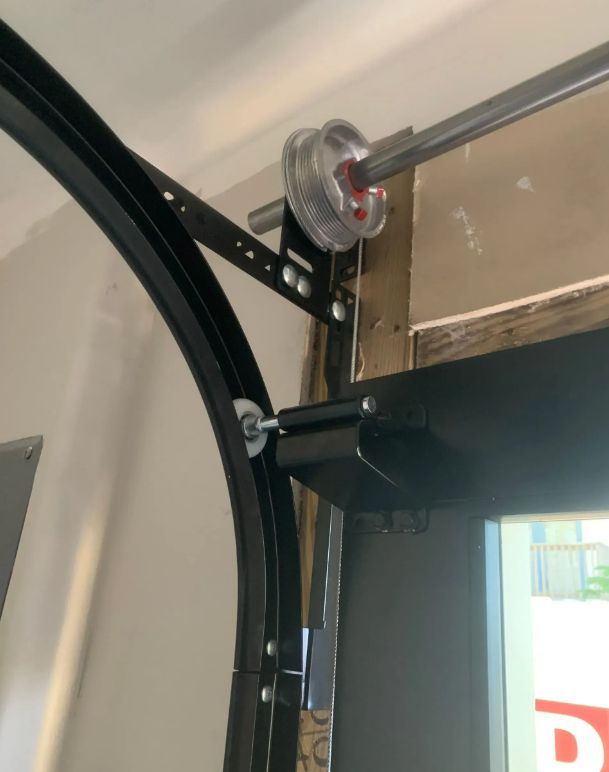 Close-up of a garage door track and pulley mechanism mounted near the ceiling.