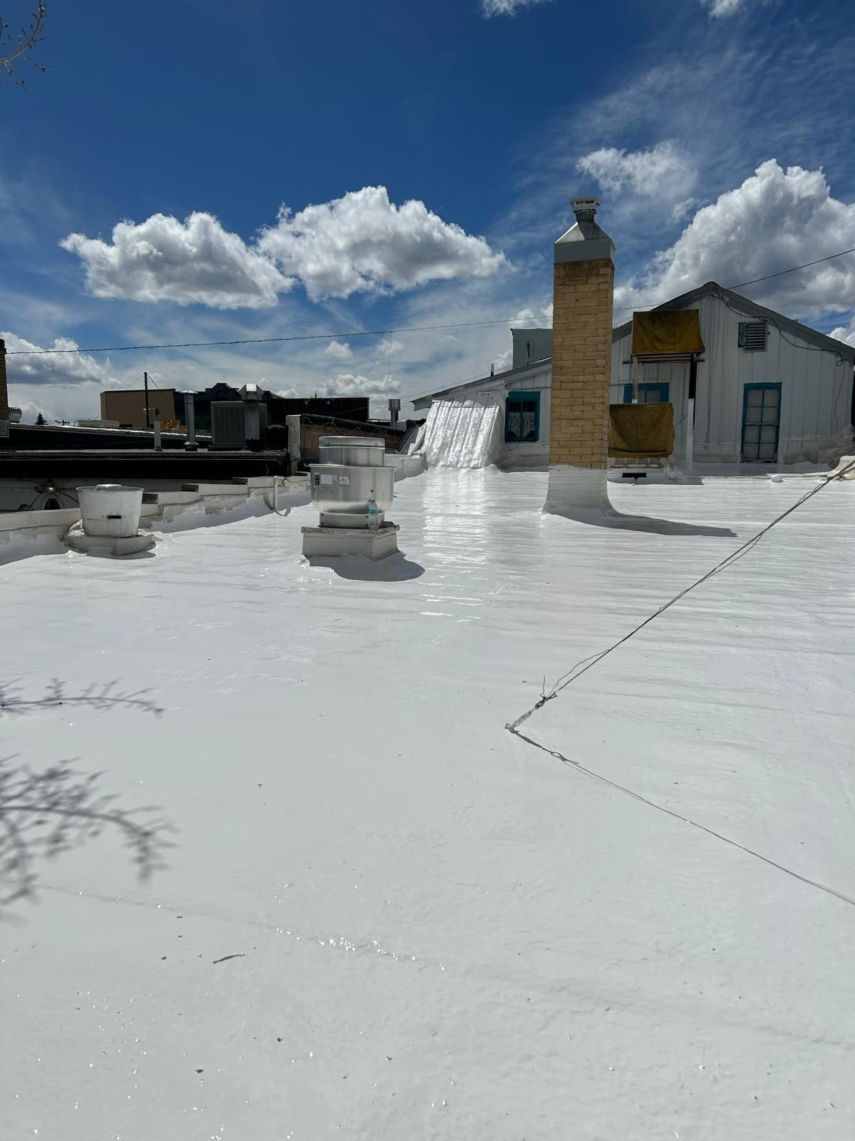 A white roof with a chimney on top of it