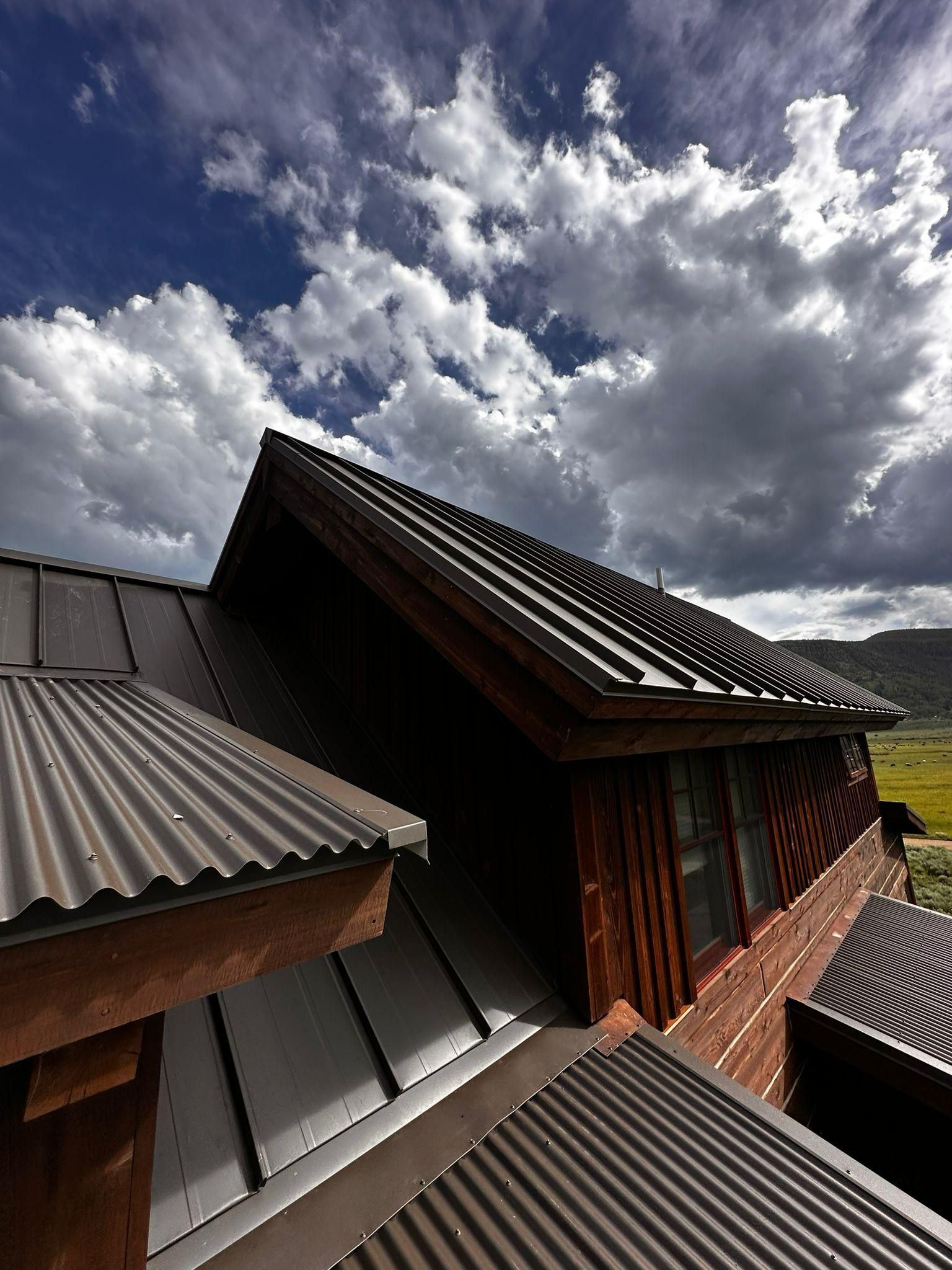 A roof of a house with a cloudy sky in the background