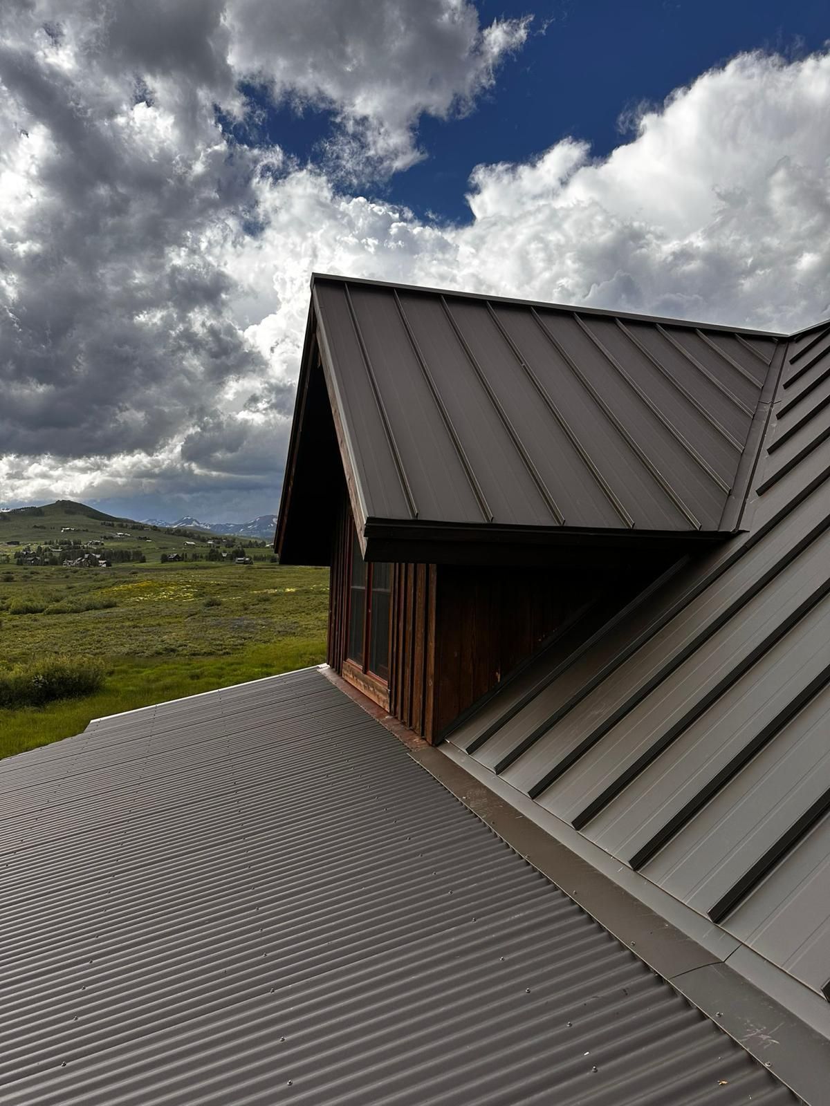 A roof of a house with a cloudy sky in the background