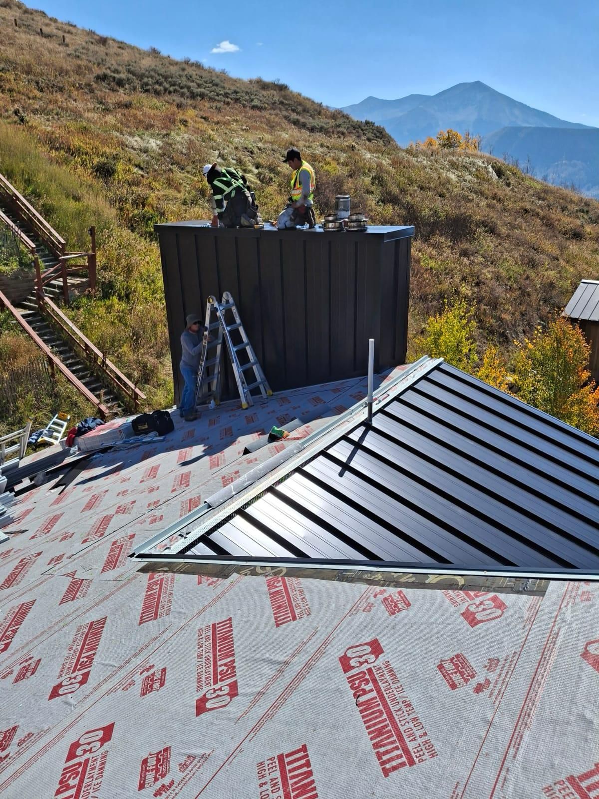 A man is working on the roof of a house with a ladder