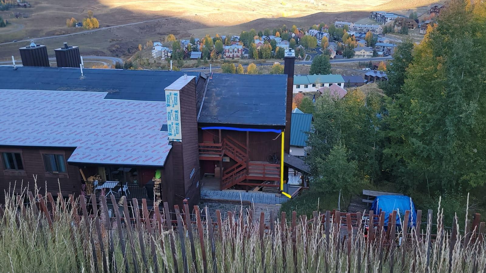 An aerial view of a house with a yellow arrow pointing to the backyard