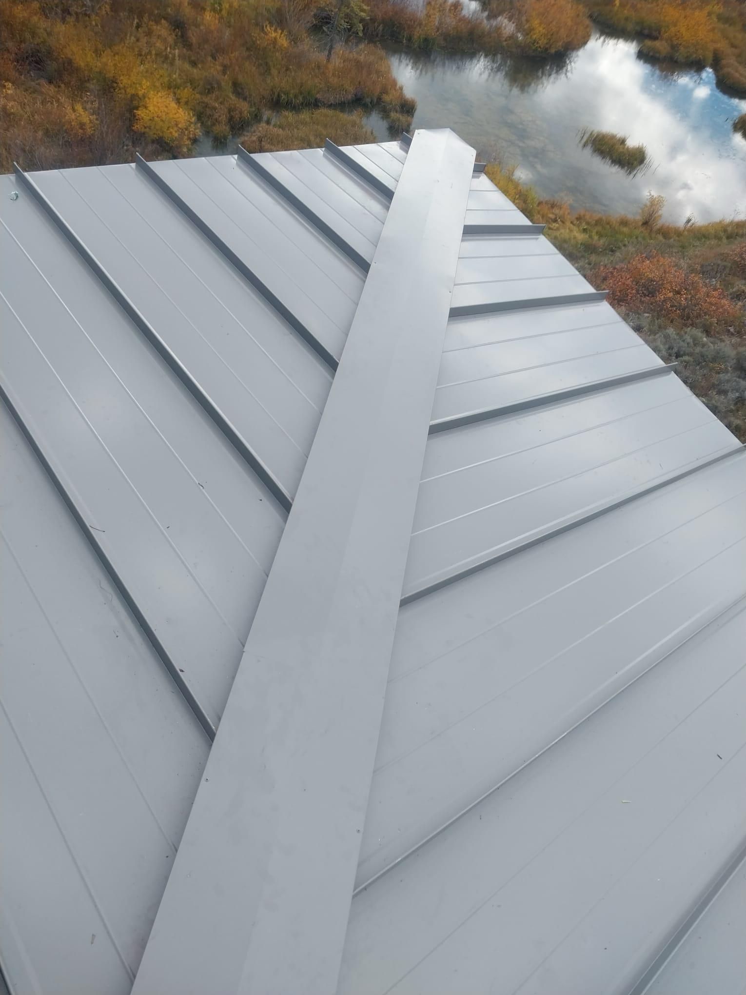 A close up of a roof with a pond in the background