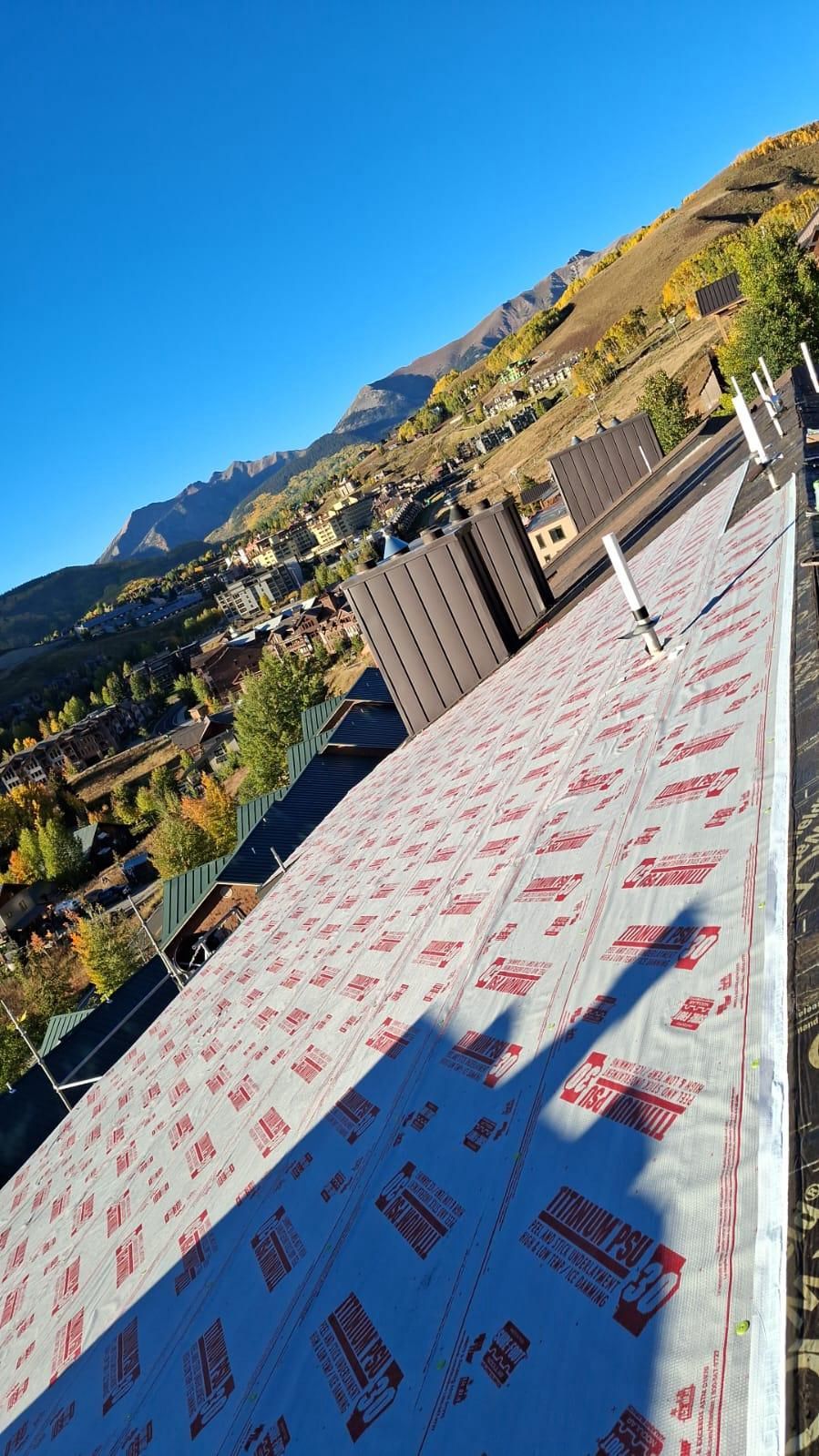 A roof with a view of a city and mountains in the background