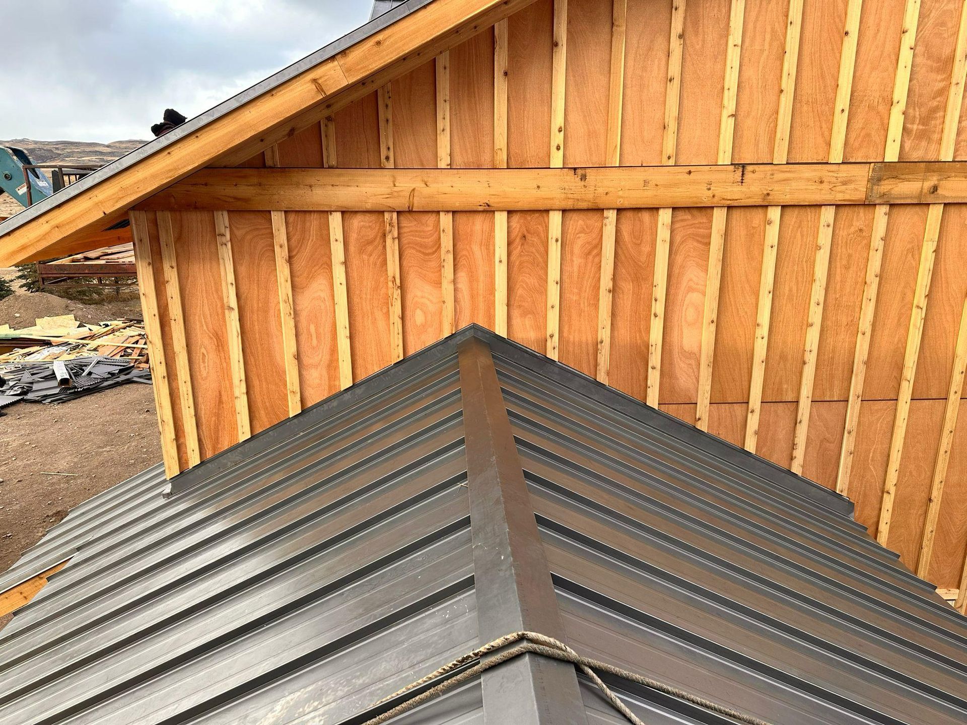 A metal roof is being installed on a wooden building