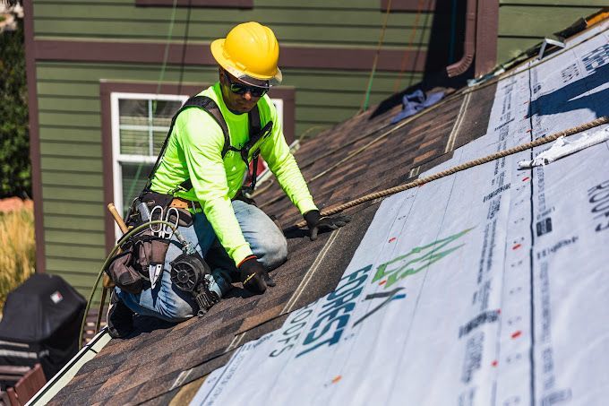 A man is working on the roof of a house.