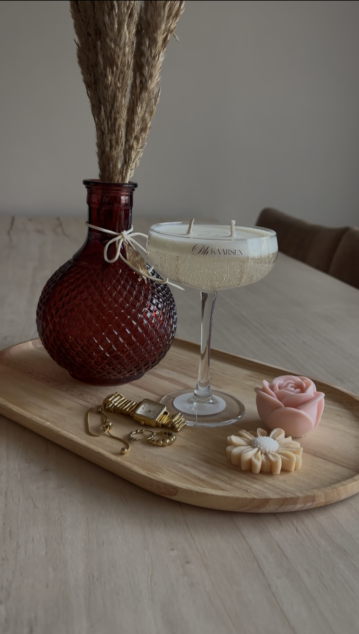 Champagneglas op een tafel met witte bloemen en een glazen karaf op de achtergrond.