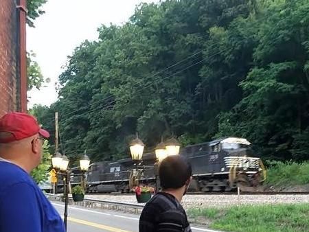 Two men are looking at a train on the tracks