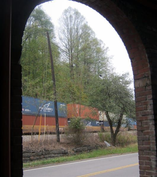 A view of a train from a brick archway