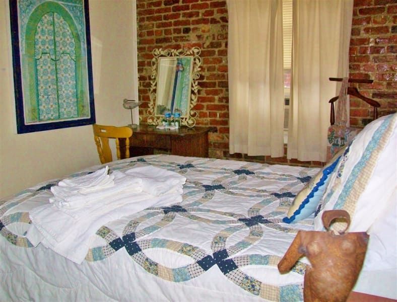 A bedroom with a large bed and a brick wall