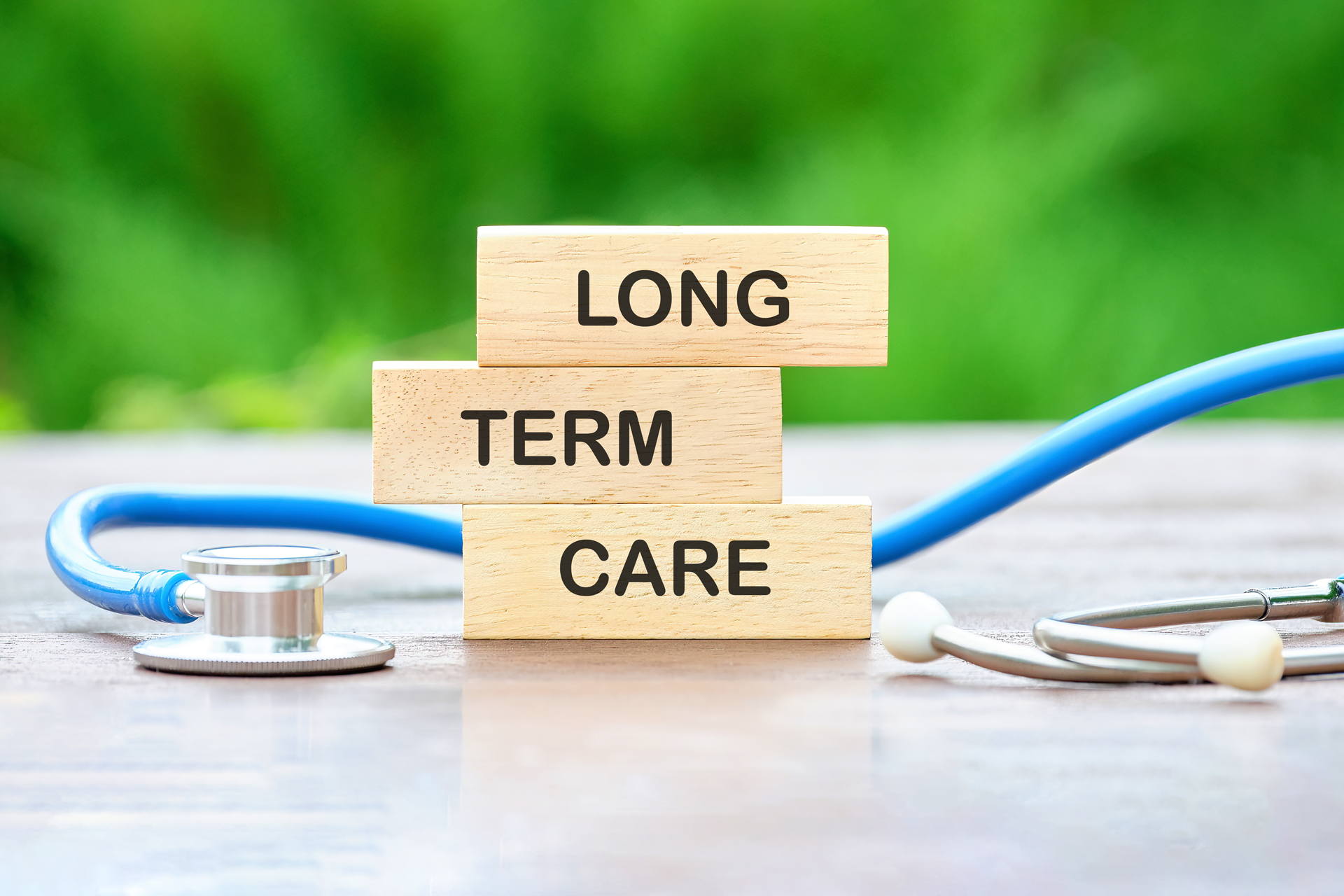 The word long term care is written on wooden blocks next to a stethoscope.