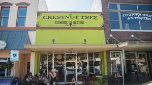 A group of people are sitting outside of a green building.