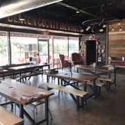 A large room filled with tables and benches in a restaurant.