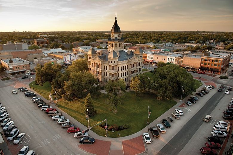 An aerial view of a city with a large building in the middle