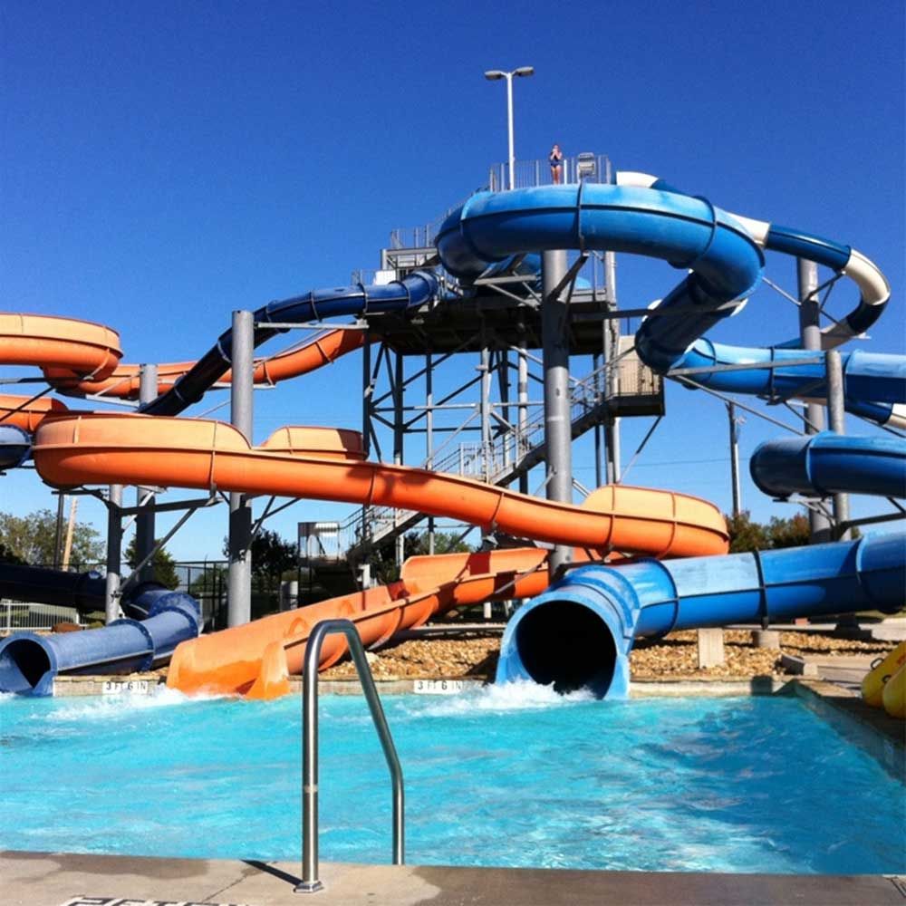 A water park with blue and orange slides and a pool